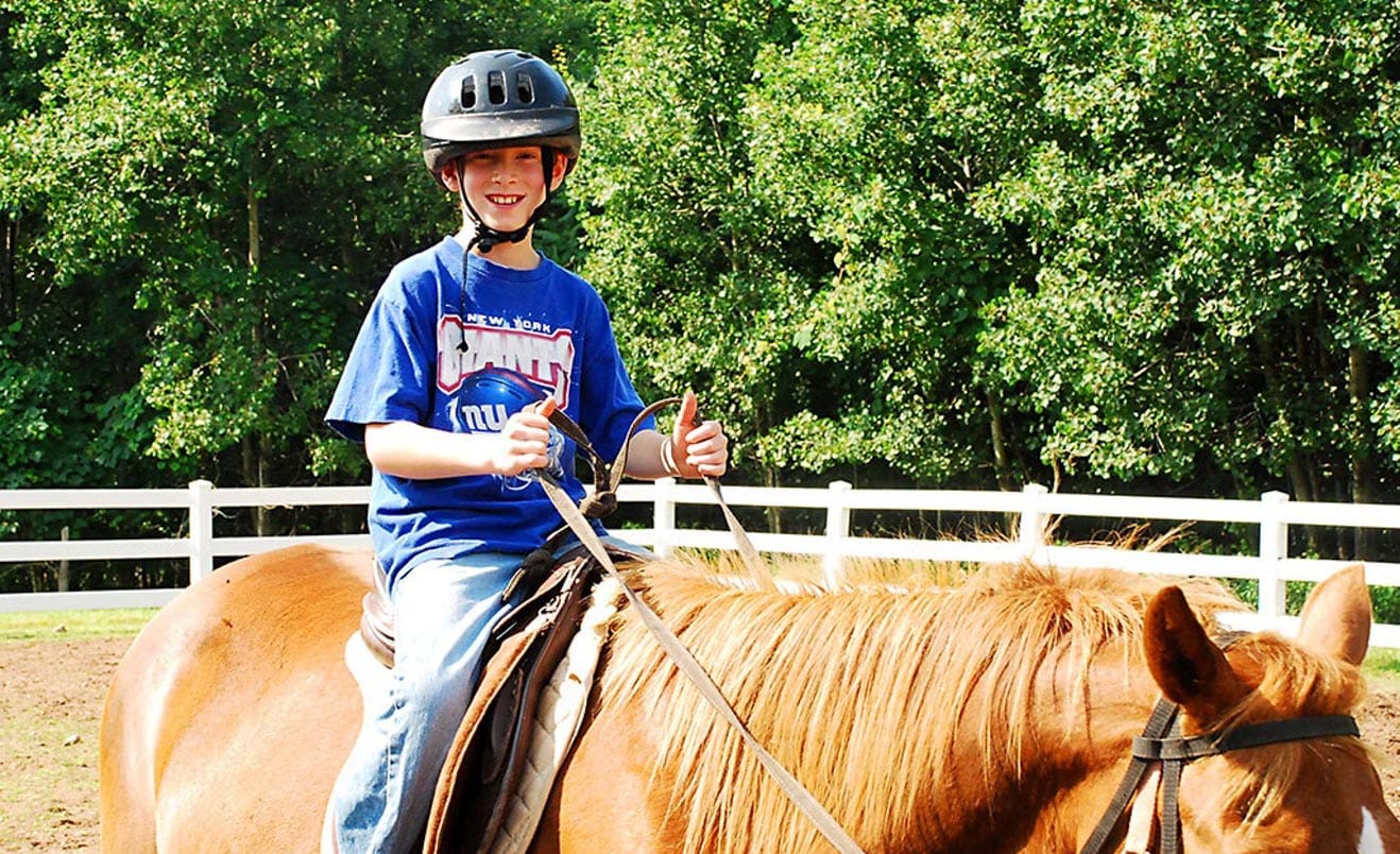 Male camper riding a horse